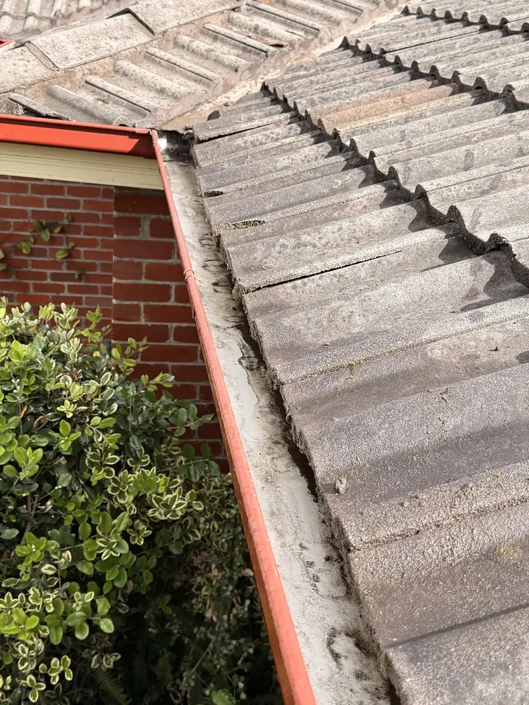 The same gutter cleared out, bare metal visible